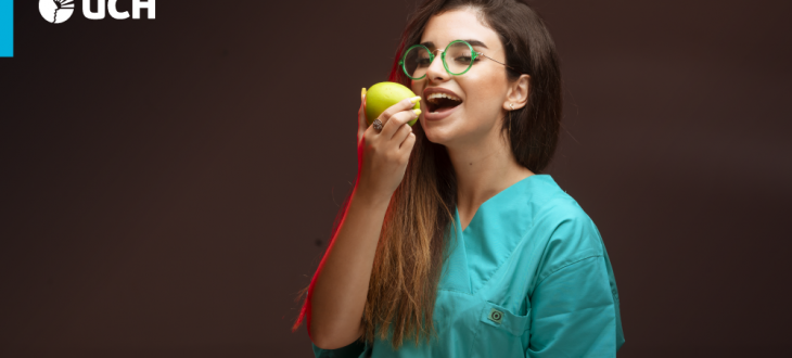 estudiante de la carrera de Nutrición y Dietética consumiendo una manzana verde.
